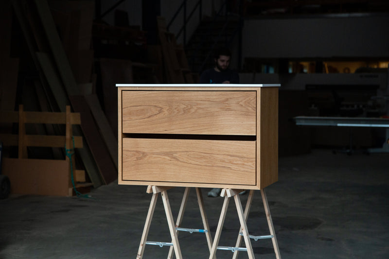 Væghængt badmøbel i fineret eg med to skuffer og let svævende udtryk