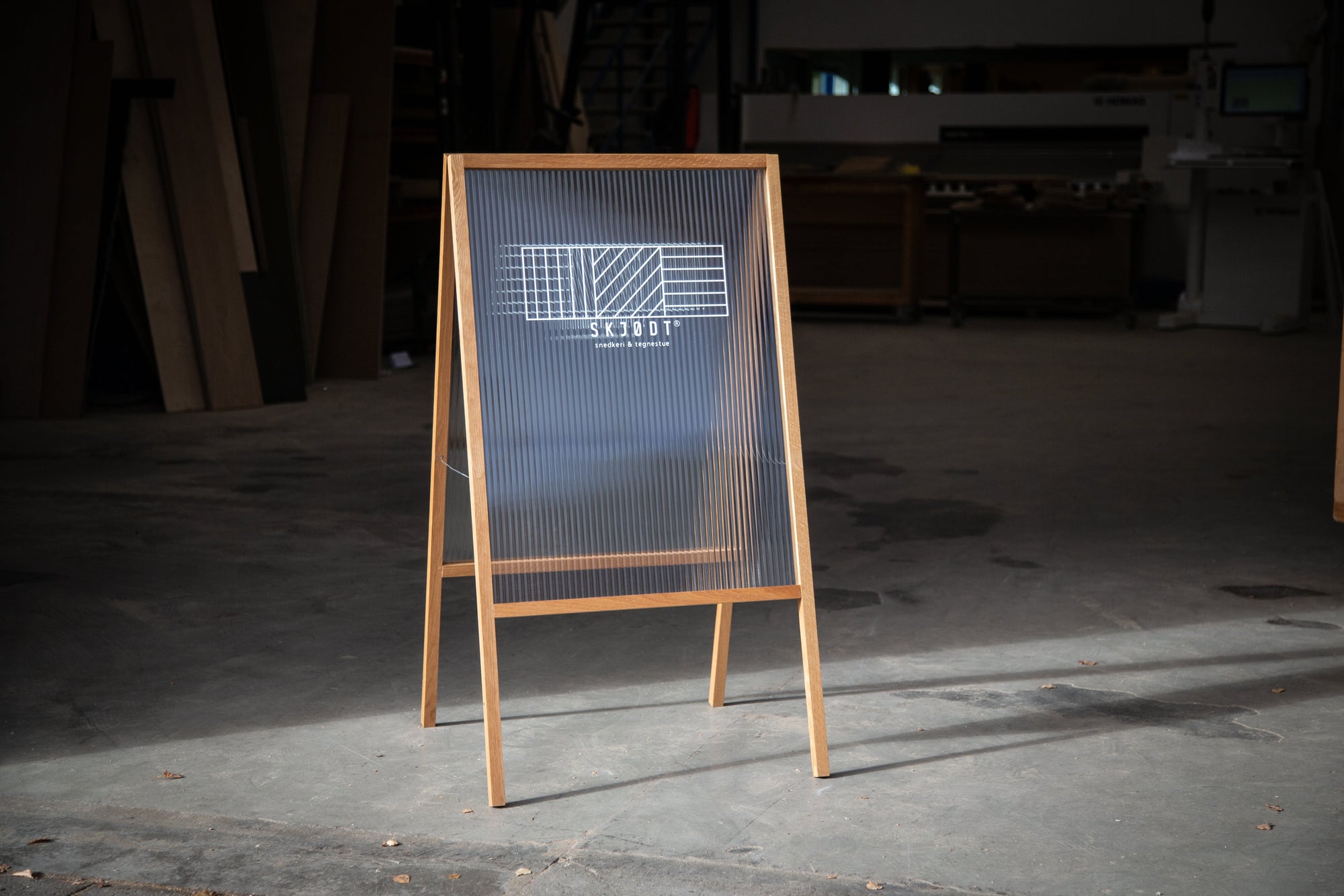 Stilrent butiksskilt håndlavet i massivt egetræ med transparent rillet plast