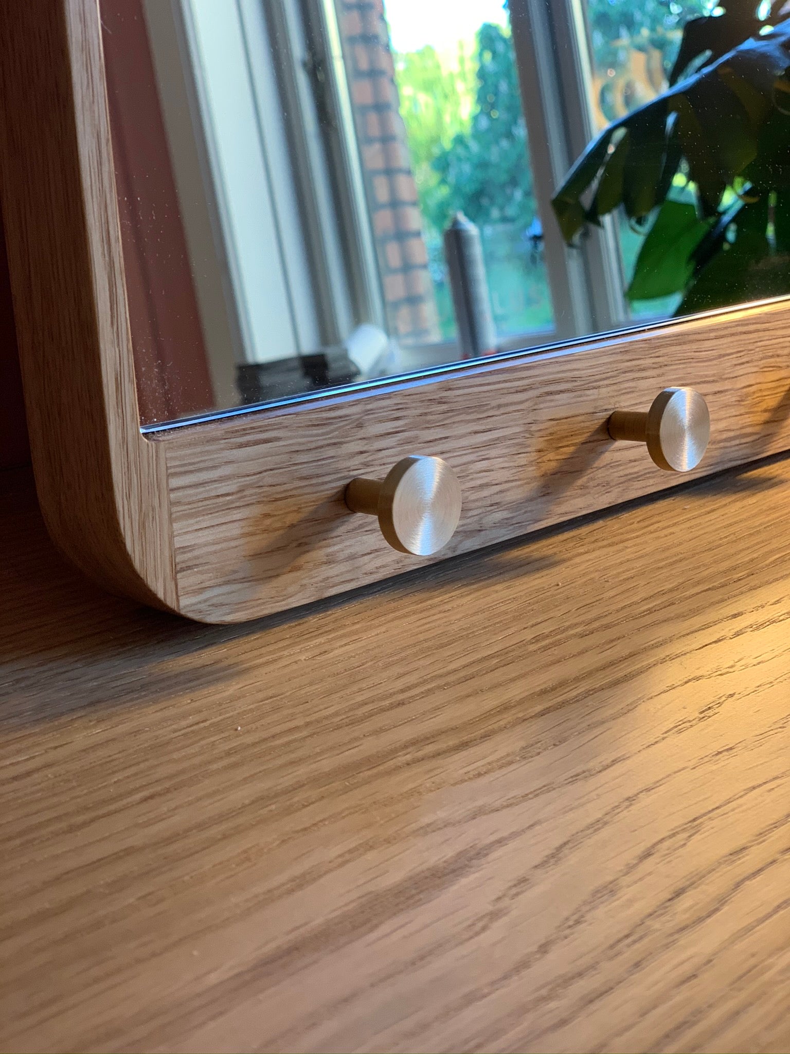 Detalje af spejl i massiv eg med knager i messing